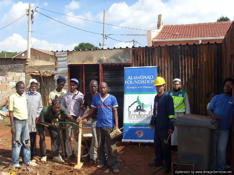 AIF team members with volunteers rebuilding the burnt shacks