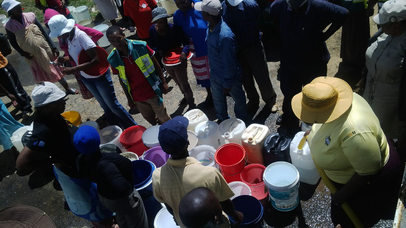 Lining up with their vessels and buckets to collect water from mobile tanks 